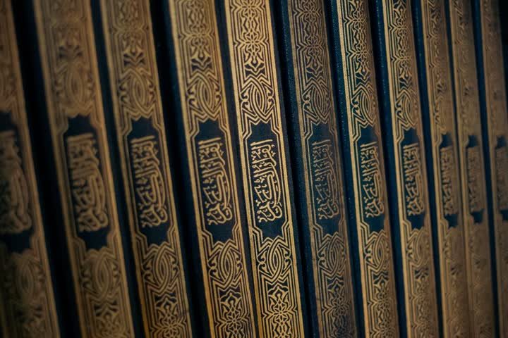Tranches dorées de volumes du Coran alignés